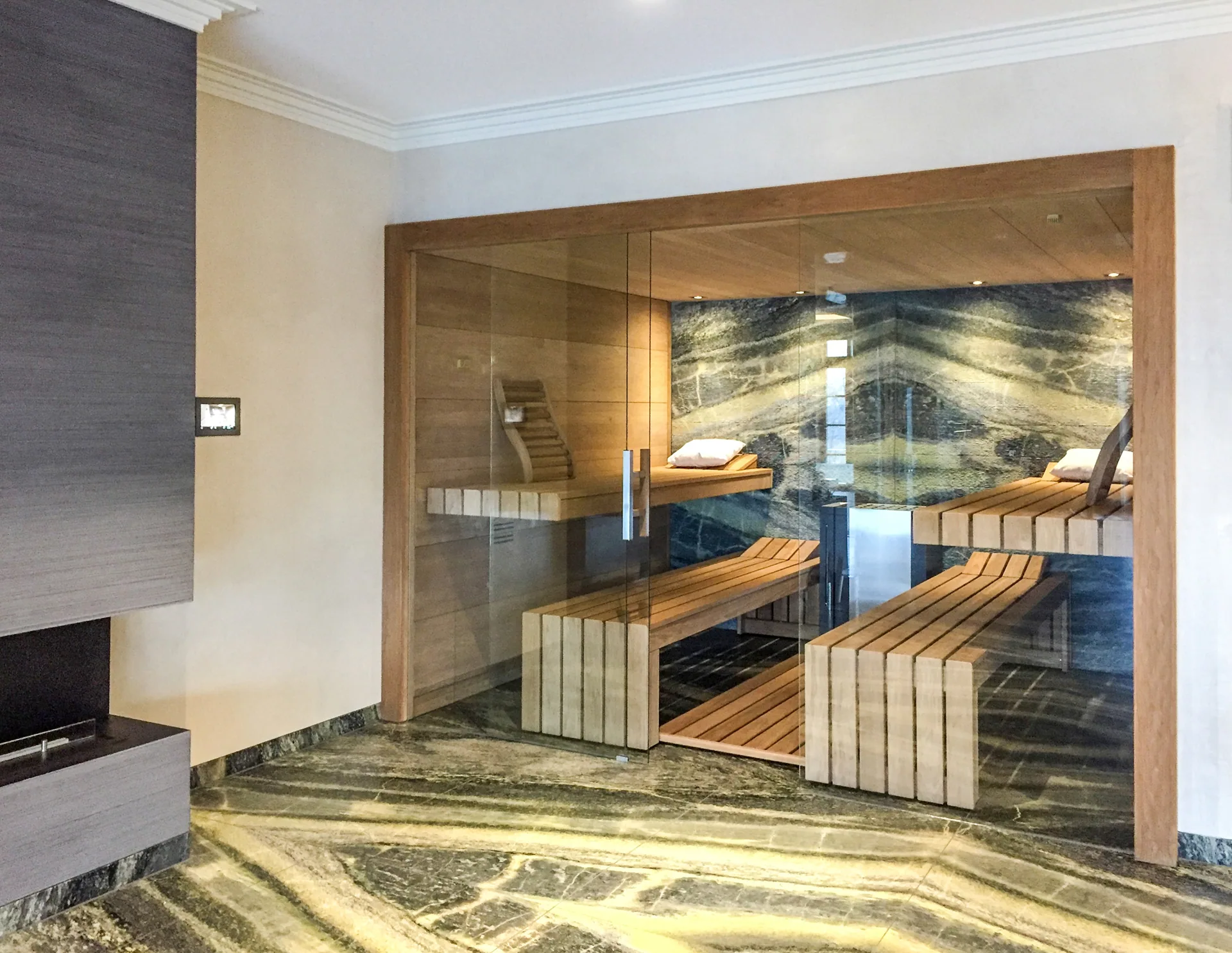 Moderne Innensauna mit Glasfront und beleuchteter R&uuml;ckwand